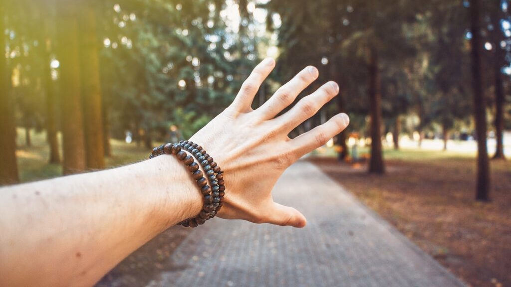 a guy wearing diy bracelets made with string