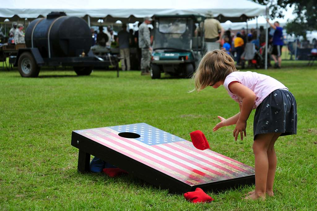 girl playing cornhole game